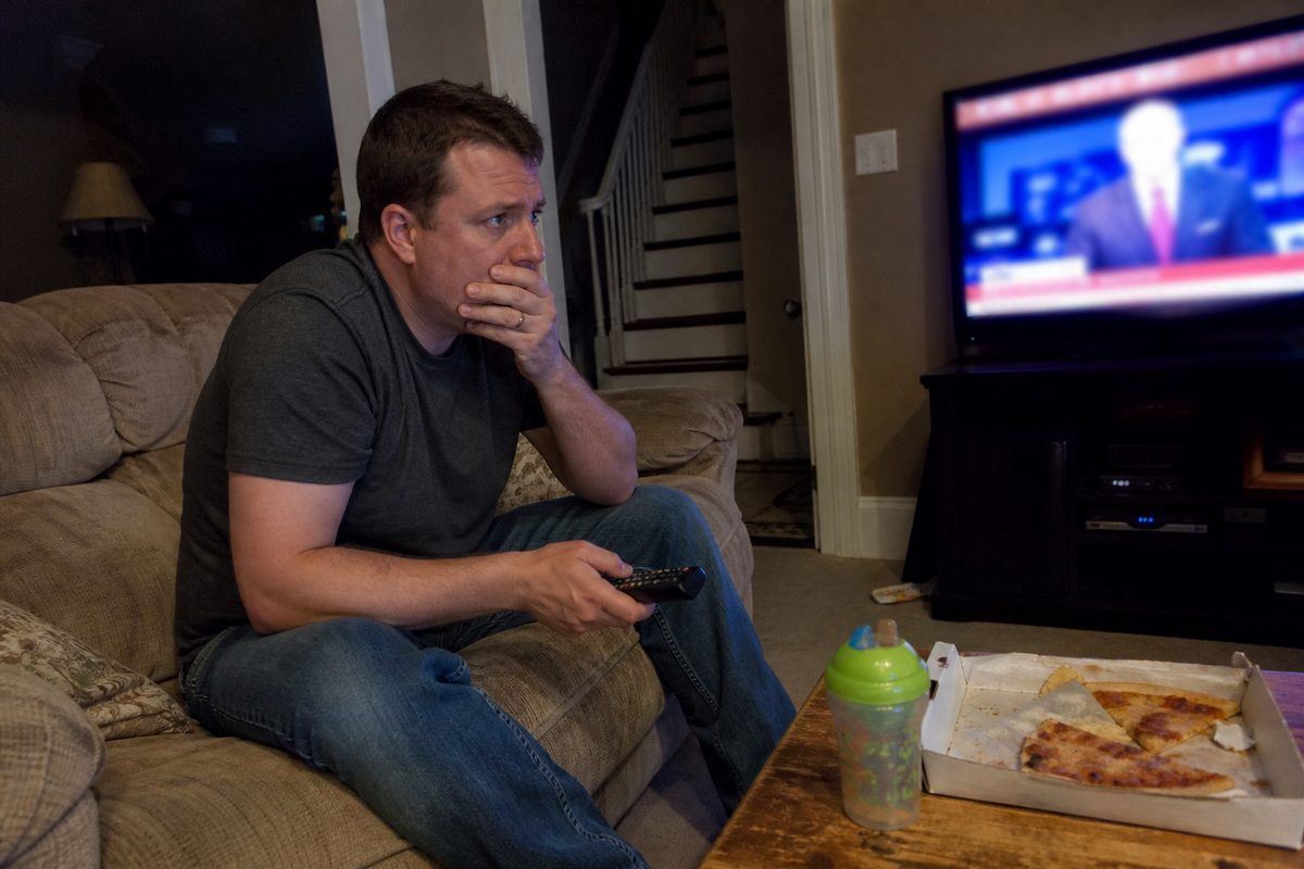 A dad watching late-night firearm news in his living room