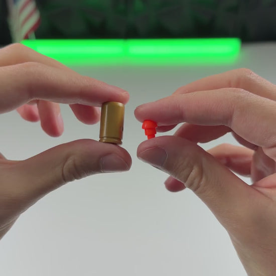 A red dart is fitted into a gold casing.